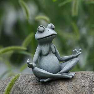 Dettaglio di una statua di rana meditante in resina con trama di pietra su roccia