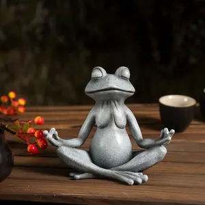 Close-up of a zen yoga frog statue with stone texture and matte finish on a wooden table