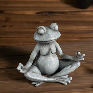 Meditating frog statue with stone texture for home garden decor on wooden table