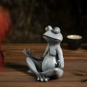 Macro shot of meditation frog statue with stone texture on a dark wood table