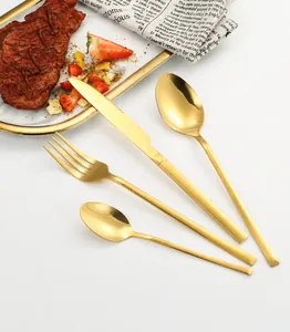 Detalle del juego de cubiertos de acero inoxidable oro mate con diseño moderno y delgado