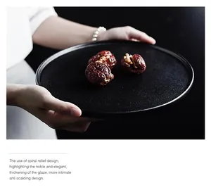 Detail of black ceramic steak plate with spiral relief texture and anti-scald thick glaze
