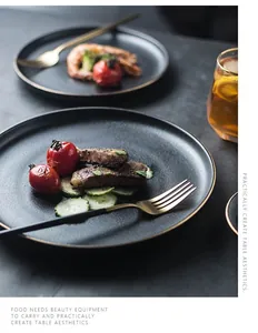 Detail of matte black ceramic steak plate with elegant gold rim and cutlery