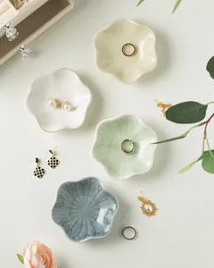 Macro shot of flower-shaped ceramic jewelry trays showing petal edges and glossy glaze