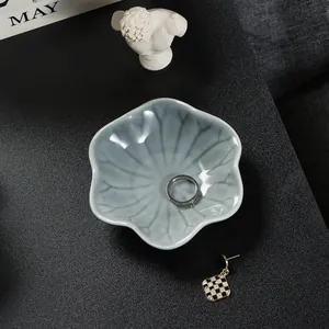 Lotus shaped light blue ceramic jewelry tray with silver ring and checkered earring