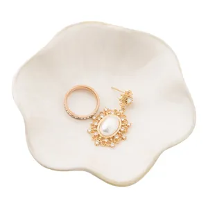 Ceramic petal jewelry tray with elegant rose gold diamond ring and pearl earrings