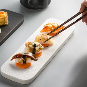 Rectangle white ceramic sushi plate with stone texture and appetizers on the surface