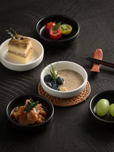 Detail view of round ceramic dipping bowls in black and white for sauces and snacks