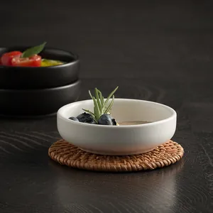 Minimalist white ceramic sauce dish with handcrafted woven rattan coaster base