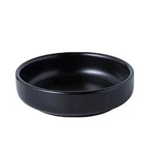 Minimalist matte black ceramic sauce dish with a sleek round shallow design for home dining