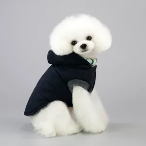 Detail of navy blue hooded dog vest with snap buttons and grey ribbed trim on small white dog