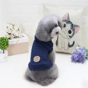 Detail of navy blue knitted dog sweater with thick cable pattern and leather tag