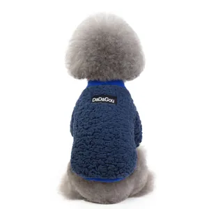 Detailed view of dark blue fleece vest texture and brand label on small dog apparel