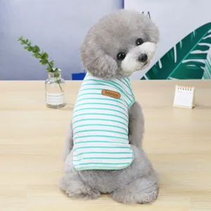 Detail of mint green striped pet vest showing the leather logo tag on cotton fabric