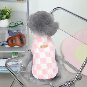 Pink and white checkered fleece pet vest with brown leather tag on a gray poodle