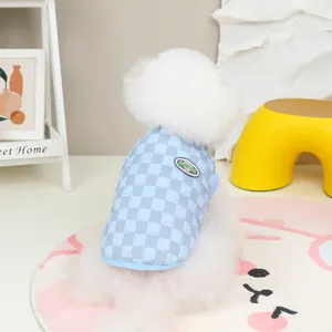 Quilted checkerboard pet vest with brand patch worn by a small white dog in cozy setting