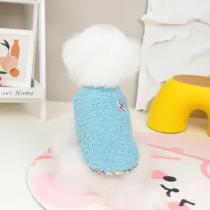 Blue fleece pet vest with floral trim and red embroidery on a small white dog