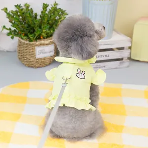Detail view of yellow pet harness vest with ruffles and bunny embroidery on a small dog