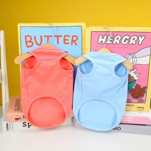 Macro detail of coral and sky blue cotton pet vests with miniature wooden hangers