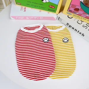 Detail of red and yellow striped pet vests with cute embroidered smiley face patches