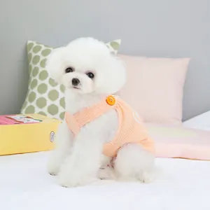 Cute peach waffle knit pet vest with bear button for small dogs shown on white Bichon