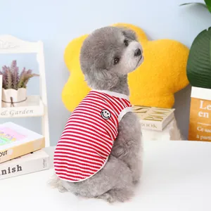 Close-up of red and white striped pet vest with smiley face patch on a small dog