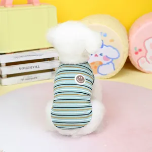 Dettaglio del gilet a righe in cotone per animali con toppa a sorriso su un cane bianco
