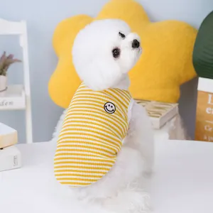 Detail of yellow striped pet vest featuring a smiling face patch and breathable fabric