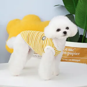 Puppy in yellow and white striped vest with a smiley face print for small dogs