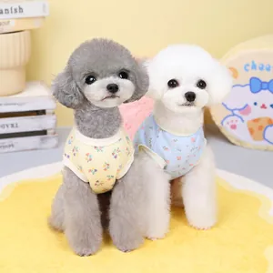 Detailed view of two small dogs wearing floral cotton waffle vests in blue and yellow