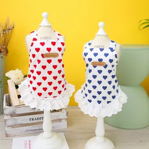 Detail of red and blue heart print pet dresses with delicate white lace trim and leather logo