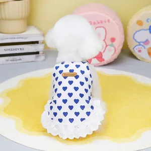 Close-up of white pet dress with blue heart patterns and delicate lace hem detail