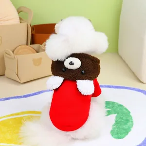 Detail of a pet red sweater and brown bear hoodie set on a white dog in a cozy home