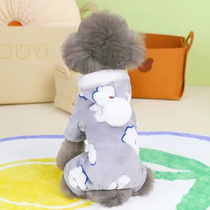 Detail eines warmen grauen Plüsch-Haustier-Jumpsuits mit weißen Wolken und Pompons