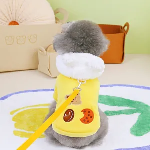Close-up of yellow dog hoodie with cartoon bear print and fleece hood with leash