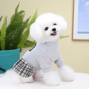 Detail of grey knitted pet dress with brown plaid skirt and gold crown embroidery