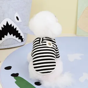 Close-up of black and white striped pet sweater with a metal D-ring and yellow smiley face