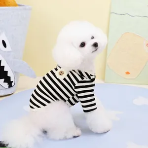 Classic black and white striped pet T-shirt with a smiley face patch on a small white dog