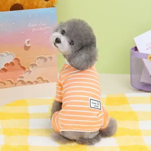 Detail of orange striped pet pajamas featuring a 'keep smile' patch on cotton fabric