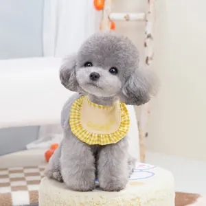 Yellow pet bib with ruffle trim and Korean embroidery on a grey toy poodle