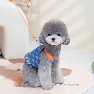 Detalle del arnés vaquero azul para perro con estrellas blancas y correas naranjas
