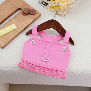 Pink denim pet vest with long fringes and white D-ring on a wooden hanger for cats and dogs
