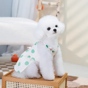 Close-up of white pet dress with large green polka dots and ruffled collar on small dog
