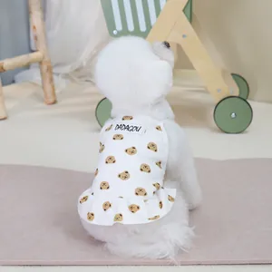 Close-up of white pet dress with brown bear prints and ruffled hem on a cute puppy