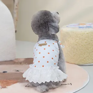 Detailed view of white pet dress with orange polka dots and delicate lace trim hem
