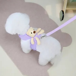 Detail of lavender pet harness set with plush bear toy and leash on a white dog