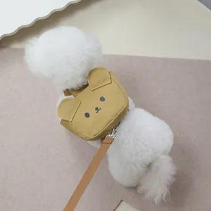 Détail du harnais sac à dos en toile jaune avec broderie ours sur un petit chien blanc