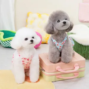 Rosa und blaue Haustierkleider mit Pfirsichmuster für Hunde und Katzen auf Koffern