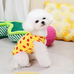 Detail of a breathable yellow dog vest with red strawberry print on a small white dog