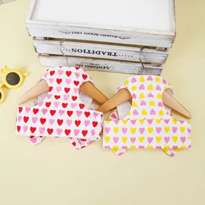 Breathable mesh pet harness with heart print on wooden hanger against yellow background